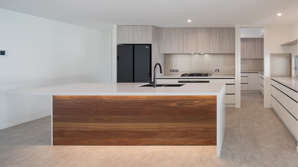 Photo of a large contemporary single-wall open plan kitchen in Brisbane with a built-in sink, recessed-panel cabinets, light wood cabinets, engineered stone countertops, beige splashback, glass sheet splashback, ceramic flooring, an island, beige floors and beige worktops.