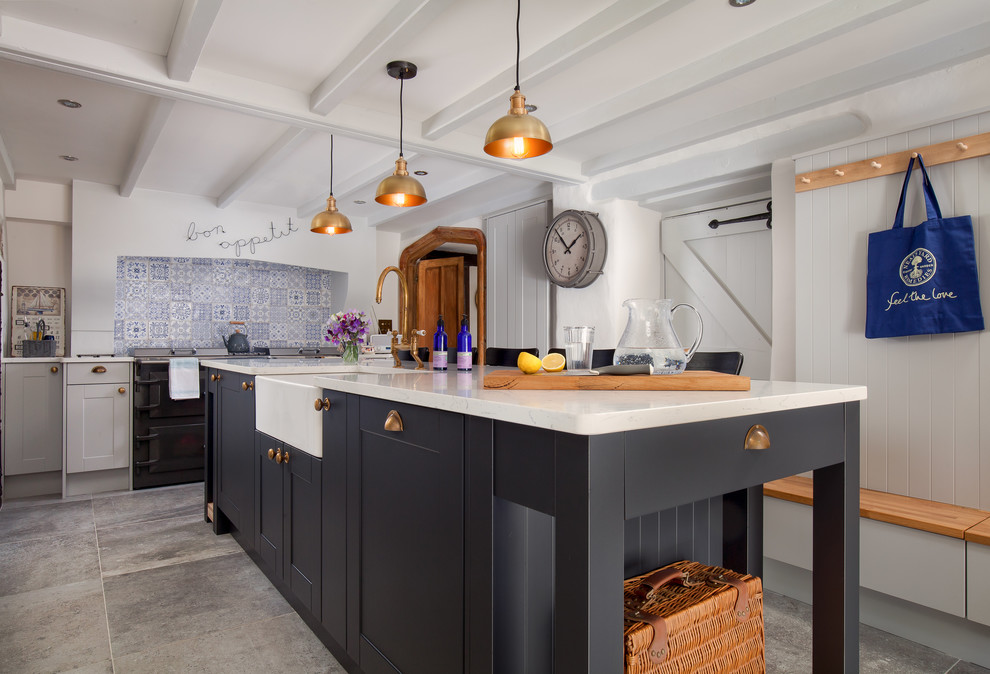 Example of a mid-sized farmhouse slate floor and gray floor enclosed kitchen design in Cornwall with a farmhouse sink, multicolored backsplash, ceramic backsplash, an island, recessed-panel cabinets, gray cabinets and quartzite countertops