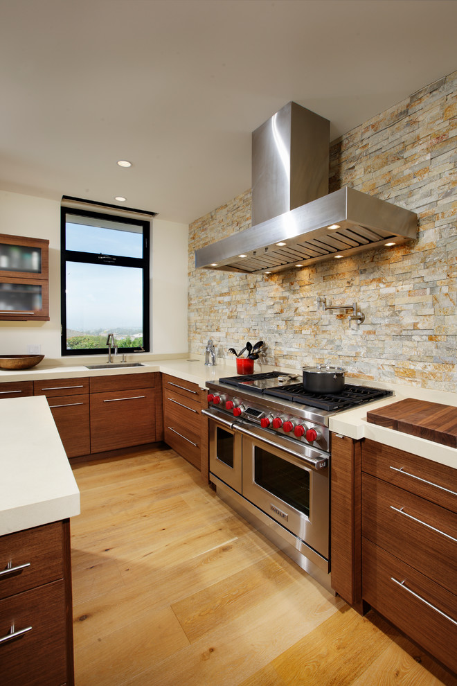 Exempel på ett stort modernt kök, med en undermonterad diskho, släta luckor, skåp i mellenmörkt trä, bänkskiva i kvartsit, beige stänkskydd, stänkskydd i keramik, integrerade vitvaror, ljust trägolv och en köksö