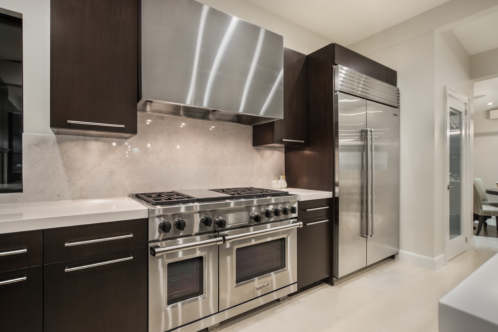 Modern inredning av ett mellanstort grå grått kök, med en undermonterad diskho, släta luckor, skåp i mörkt trä, marmorbänkskiva, vitt stänkskydd, stänkskydd i sten, rostfria vitvaror, kalkstensgolv, flera köksöar och beiget golv