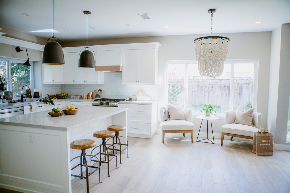 Open concept kitchen - mid-sized coastal l-shaped ceramic tile and brown floor open concept kitchen idea in San Diego with an undermount sink, shaker cabinets, white cabinets, quartz countertops, white backsplash, subway tile backsplash, stainless steel appliances and an island