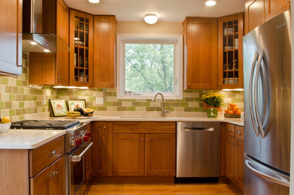 Inspiration for a mid-sized craftsman u-shaped medium tone wood floor eat-in kitchen remodel in DC Metro with an undermount sink, shaker cabinets, medium tone wood cabinets, quartz countertops, green backsplash, ceramic backsplash, stainless steel appliances and no island