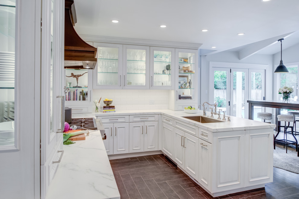 Kitchen - traditional u-shaped gray floor and ceramic tile kitchen idea in San Francisco with raised-panel cabinets, white cabinets, quartz countertops, white backsplash, white countertops, an undermount sink, paneled appliances and subway tile backsplash