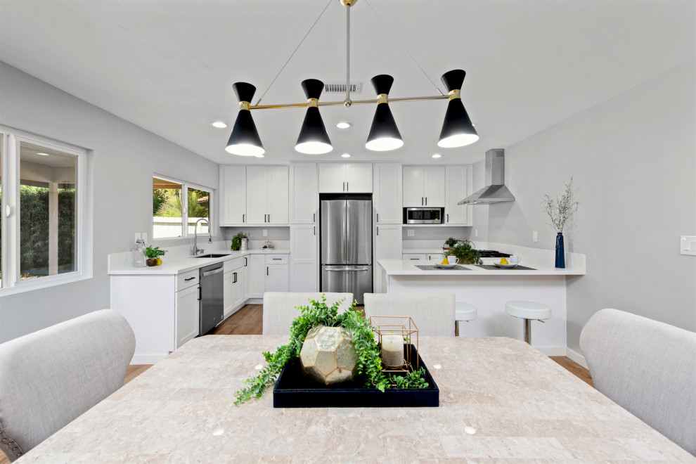 Idéer för ett mellanstort modernt vit kök, med en undermonterad diskho, skåp i shakerstil, vita skåp, bänkskiva i kvarts, vitt stänkskydd, rostfria vitvaror, vinylgolv, en halv köksö och brunt golv