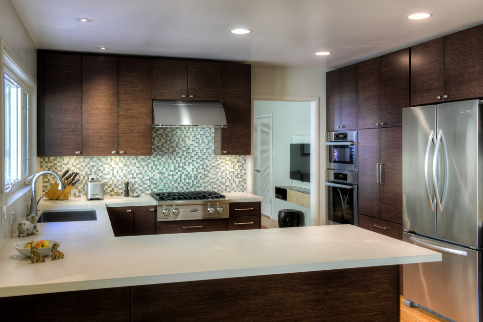 Eat-in kitchen - small contemporary u-shaped light wood floor eat-in kitchen idea in San Francisco with an undermount sink, flat-panel cabinets, brown cabinets, solid surface countertops, multicolored backsplash, stainless steel appliances, mosaic tile backsplash and no island