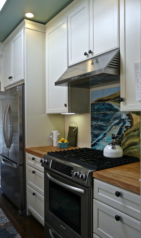 Example of a small transitional galley dark wood floor enclosed kitchen design in San Francisco with an undermount sink, recessed-panel cabinets, white cabinets, wood countertops, multicolored backsplash, ceramic backsplash, stainless steel appliances and no island