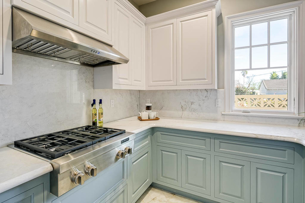 Kitchen - coastal kitchen idea in Los Angeles with an undermount sink, raised-panel cabinets, blue cabinets, white backsplash, stainless steel appliances, no island and white countertops