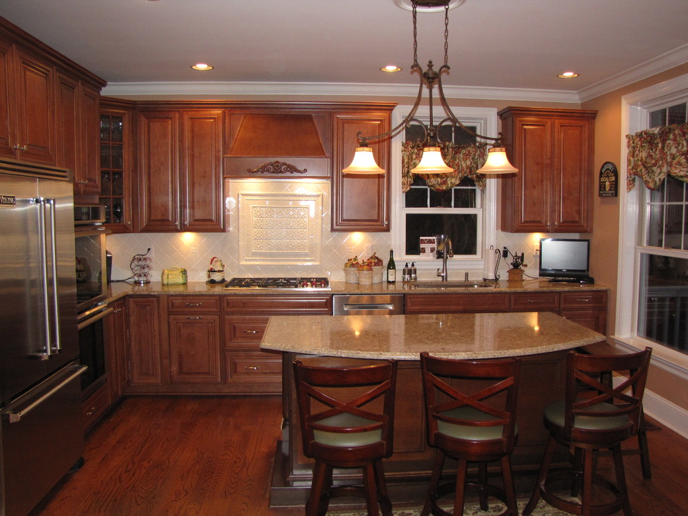 Bild på ett mellanstort vintage kök, med en undermonterad diskho, luckor med upphöjd panel, skåp i mellenmörkt trä, bänkskiva i kvarts, beige stänkskydd, stänkskydd i porslinskakel, rostfria vitvaror, mellanmörkt trägolv och en köksö