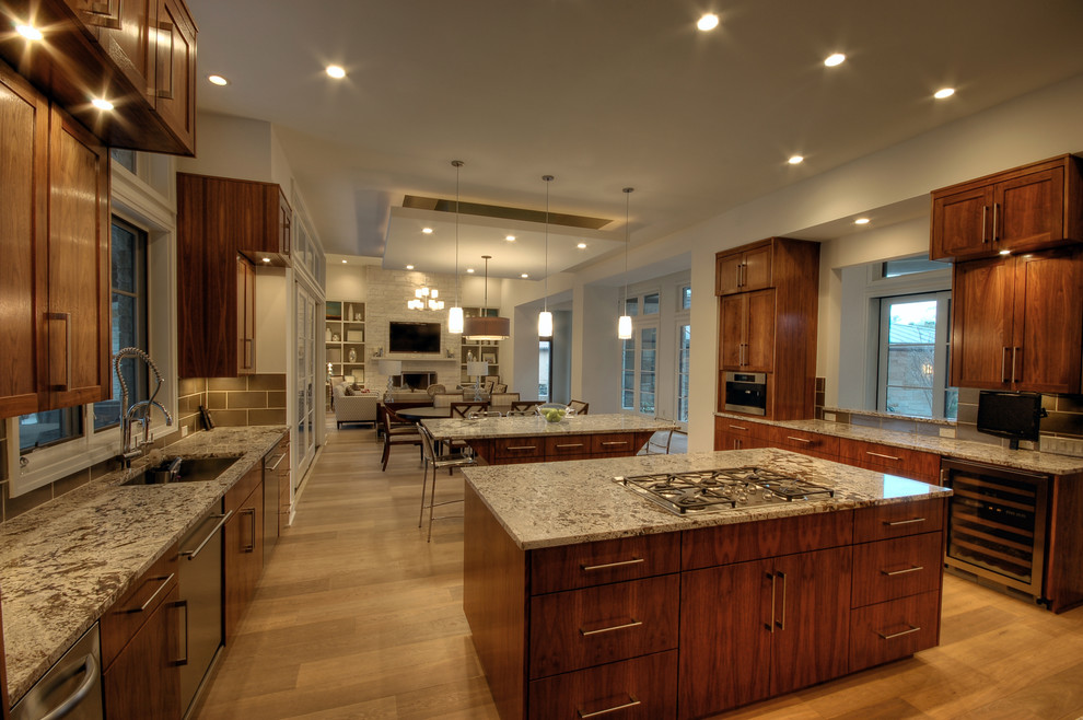 Contemporary open plan kitchen in Austin with dark wood cabinets and granite worktops.