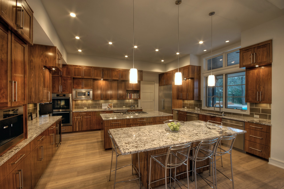 Moderne Küche mit Granit-Arbeitsplatte und zwei Kücheninseln in Austin