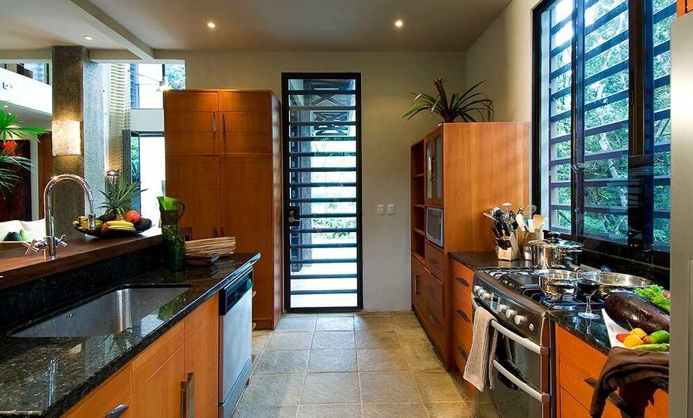 Esempio di una grande cucina design con lavello sottopiano, ante lisce, ante in legno scuro, top in granito, elettrodomestici in acciaio inossidabile e pavimento grigio