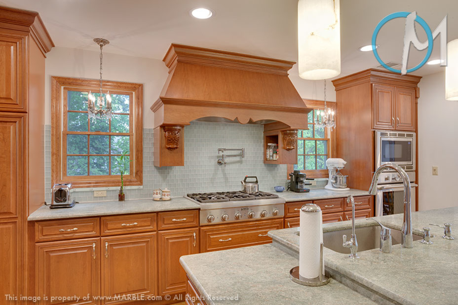 Bild på ett stort funkis kök och matrum, med skåp i mellenmörkt trä, granitbänkskiva, rostfria vitvaror och en köksö