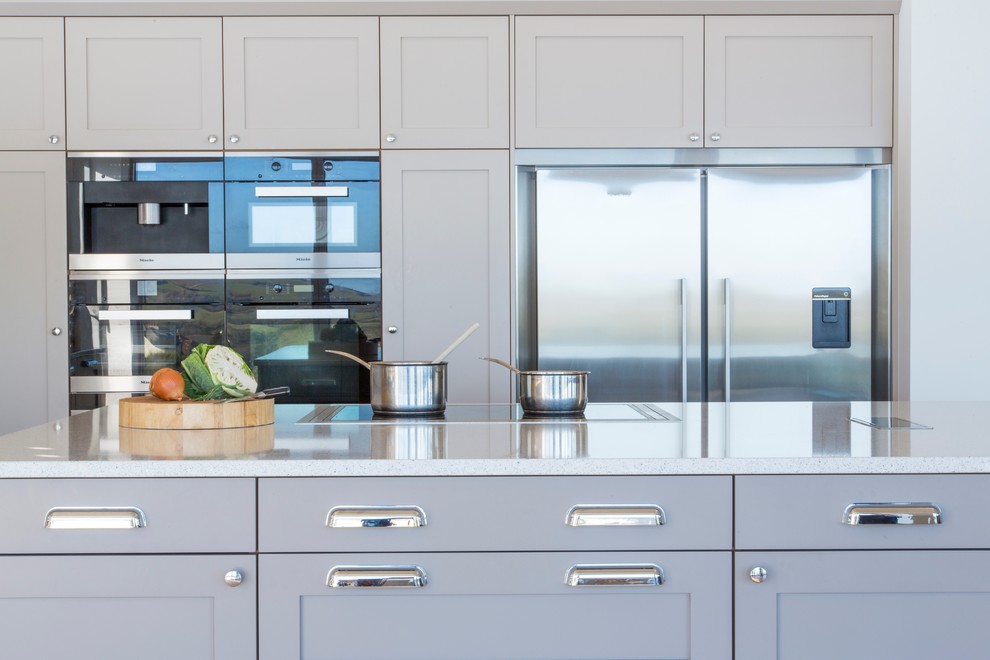 На фото: кухня в морском стиле с фасадами в стиле шейкер, серыми фасадами и столешницей из кварцита с