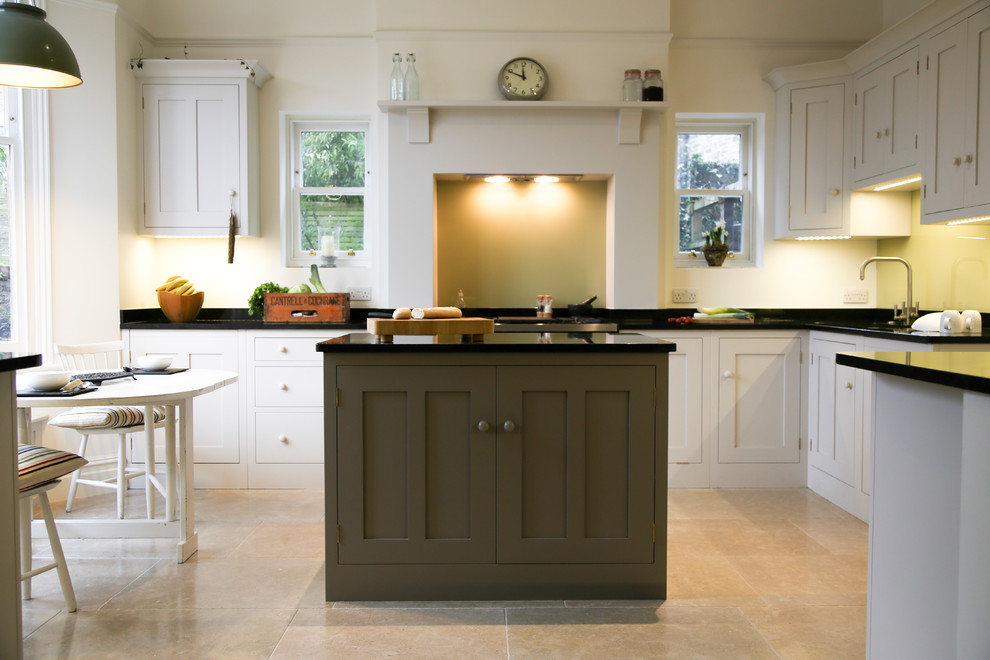 Diseño de cocina comedor lineal clásica de tamaño medio con armarios estilo shaker, puertas de armario blancas, una isla y encimera de granito