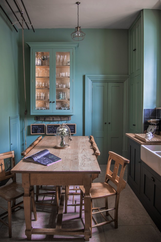 Small farmhouse l-shaped limestone floor eat-in kitchen photo in Gloucestershire with shaker cabinets, green cabinets, wood countertops, a drop-in sink, black backsplash, stone tile backsplash, colored appliances and no island