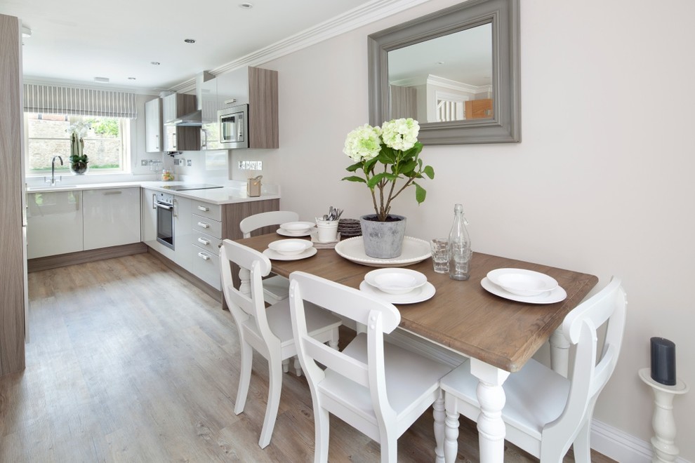 This is an example of a small contemporary kitchen/diner in Berkshire with an integrated sink, white cabinets, granite worktops, integrated appliances, light hardwood flooring and no island.