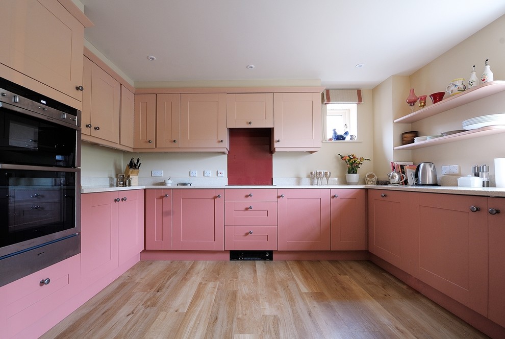 Moderne Küche in U-Form mit Granit-Arbeitsplatte, Küchenrückwand in Rot, Glasrückwand, Vinylboden und weißer Arbeitsplatte in Gloucestershire