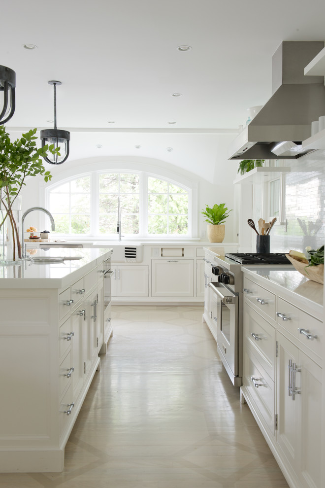 Exempel på ett avskilt, mellanstort klassiskt l-kök, med en nedsänkt diskho, luckor med infälld panel, vita skåp, marmorbänkskiva, vitt stänkskydd, stänkskydd i keramik, rostfria vitvaror, ljust trägolv och en köksö