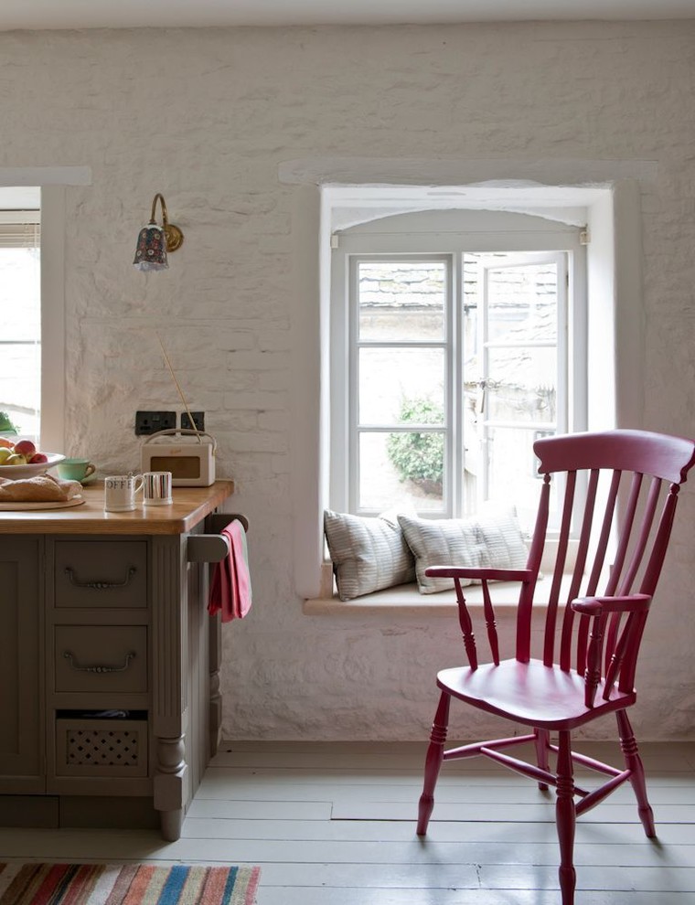 Eat-in kitchen - mid-sized farmhouse light wood floor eat-in kitchen idea in London with a farmhouse sink, flat-panel cabinets, medium tone wood cabinets, wood countertops, white backsplash, colored appliances and no island