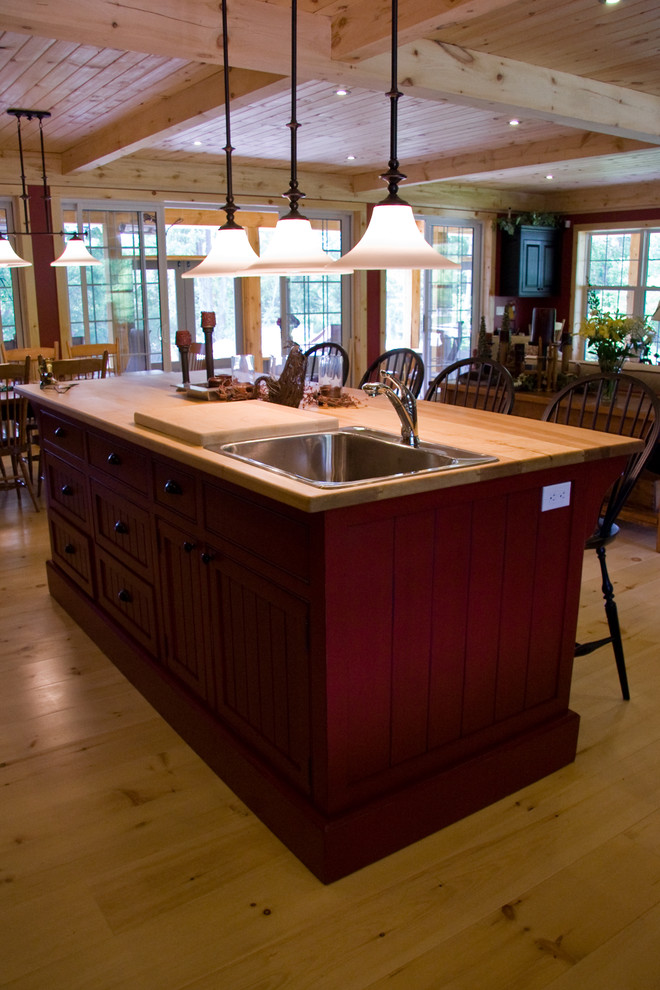 На фото: прямая кухня-гостиная в классическом стиле с накладной мойкой, фасадами в стиле шейкер, темными деревянными фасадами, деревянной столешницей, светлым паркетным полом и островом