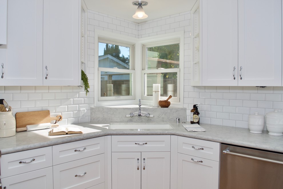 Idéer för att renovera ett mellanstort funkis vit vitt kök och matrum, med en undermonterad diskho, vita skåp, bänkskiva i kvarts, blått stänkskydd, rostfria vitvaror, ljust trägolv, en köksö och brunt golv