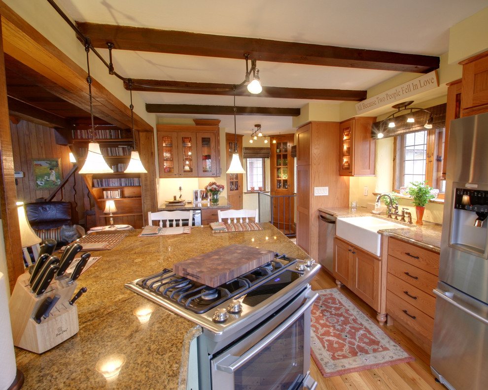 Photo of a rustic kitchen in Columbus with glass-front cabinets, stainless steel appliances, a belfast sink and granite worktops.