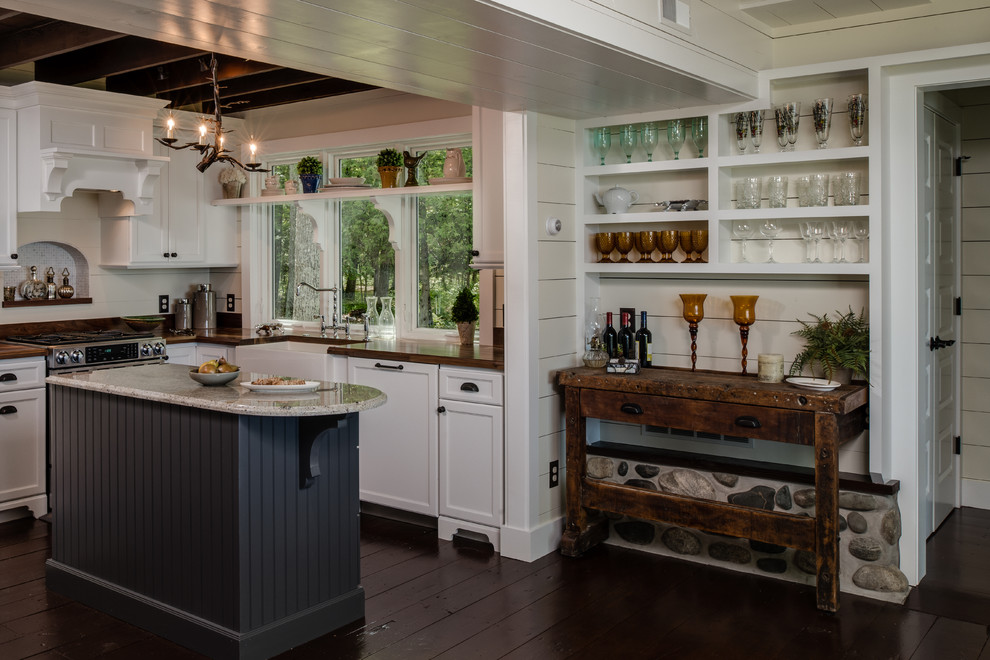 Inspiration för små klassiska kök, med en rustik diskho, luckor med infälld panel, vita skåp, träbänkskiva, vitt stänkskydd, stänkskydd i tunnelbanekakel, rostfria vitvaror, mörkt trägolv, en köksö och brunt golv