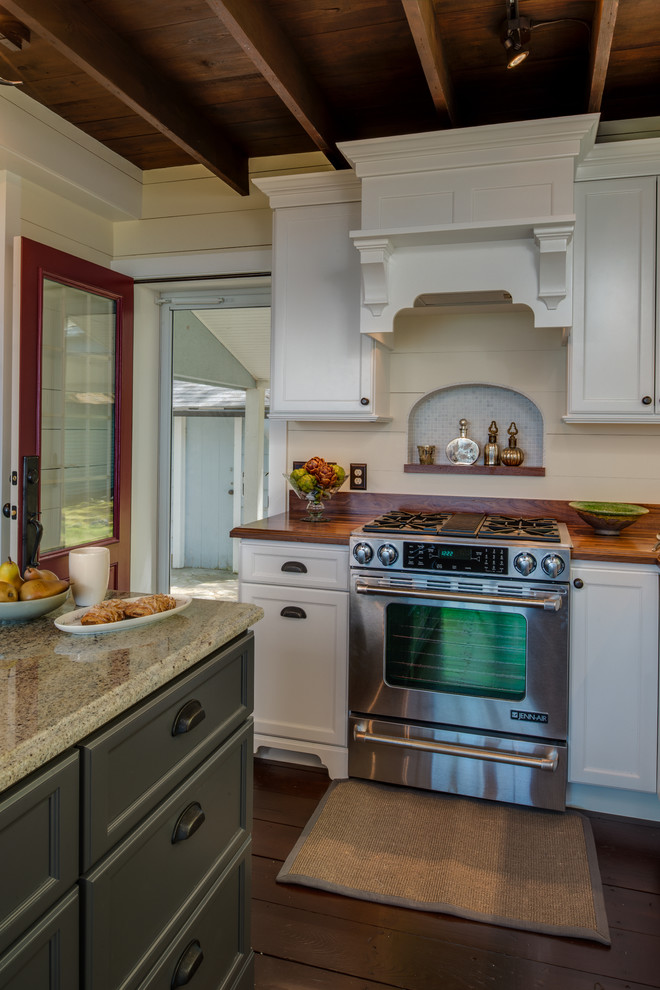 Eat-in kitchen - traditional l-shaped dark wood floor eat-in kitchen idea in Grand Rapids with a farmhouse sink, recessed-panel cabinets, white cabinets, wood countertops, white backsplash, subway tile backsplash, stainless steel appliances and an island