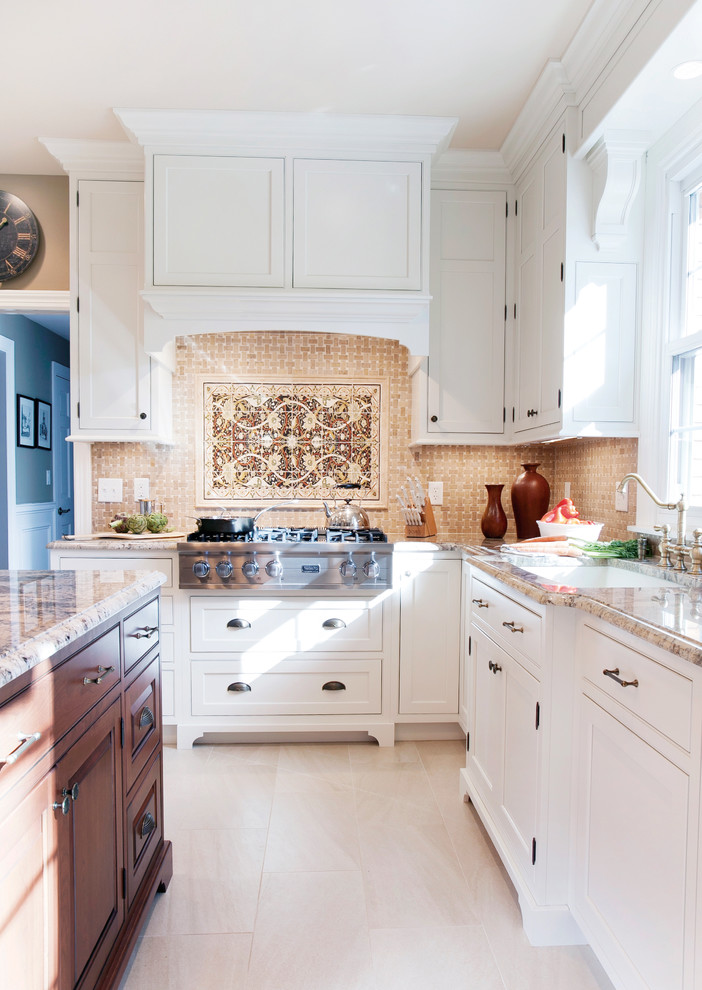 Große Klassische Küche in U-Form mit Vorratsschrank, flächenbündigen Schrankfronten, weißen Schränken, Granit-Arbeitsplatte, Küchenrückwand in Beige, Küchengeräten aus Edelstahl, Keramikboden und Kücheninsel in Sonstige
