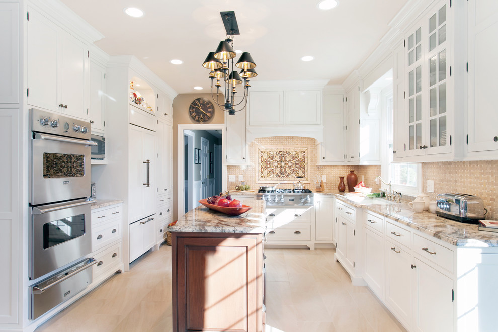 Klassisk inredning av ett stort u-kök, med skåp i shakerstil, vita skåp, granitbänkskiva, beige stänkskydd, rostfria vitvaror, klinkergolv i keramik, en köksö och en undermonterad diskho