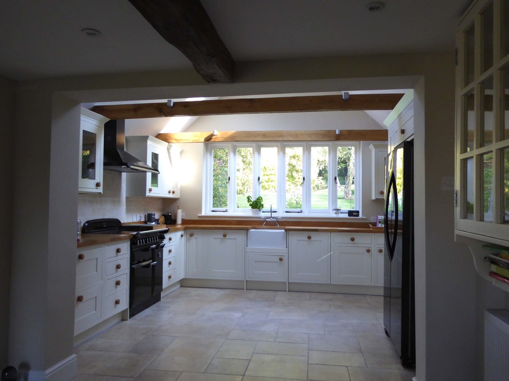 Design ideas for a large rural l-shaped open plan kitchen in Kent with a belfast sink, shaker cabinets, white cabinets, no island and beige floors.