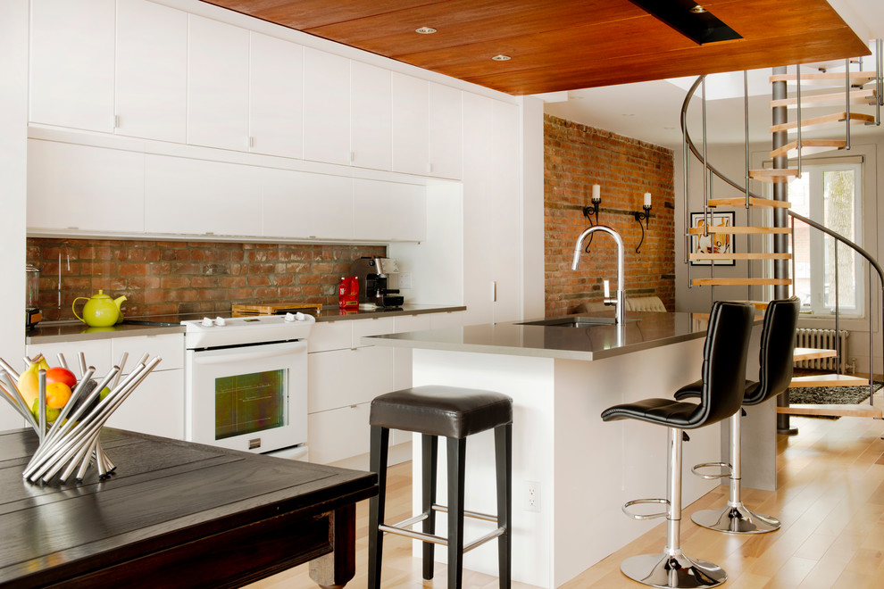 Ejemplo de cocina actual abierta con fregadero bajoencimera, armarios con paneles lisos, puertas de armario blancas y electrodomésticos blancos