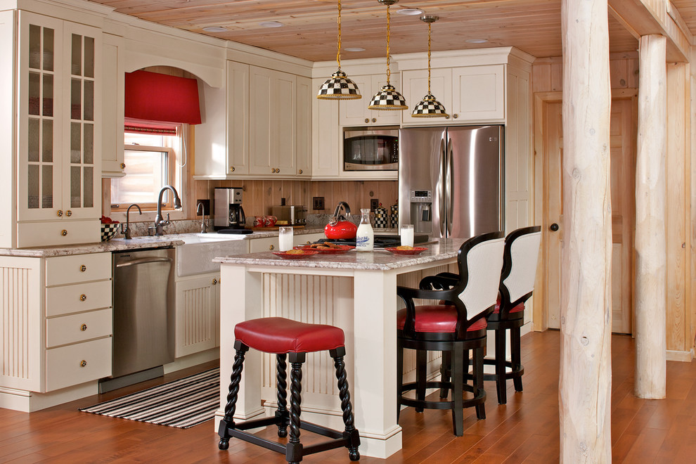 Klassisk inredning av ett kök, med en rustik diskho, luckor med profilerade fronter, beige skåp, granitbänkskiva och rostfria vitvaror