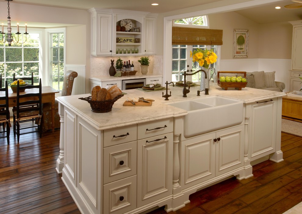Inredning av ett klassiskt stort l-kök, med en rustik diskho, luckor med upphöjd panel, vita skåp, marmorbänkskiva, vitt stänkskydd, stänkskydd i keramik, integrerade vitvaror, mörkt trägolv, en köksö och brunt golv