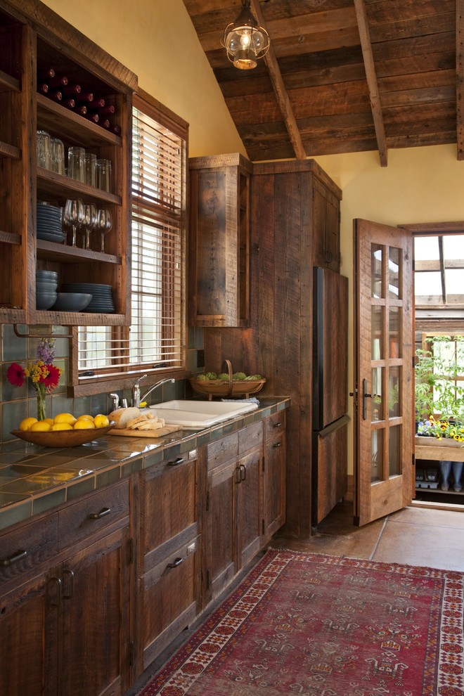 Inspiration for a rustic kitchen remodel in Other with a double-bowl sink, dark wood cabinets, window backsplash and paneled appliances