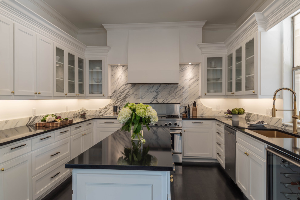 Example of a large trendy u-shaped dark wood floor and brown floor eat-in kitchen design in Dallas with a single-bowl sink, white cabinets, quartzite countertops, white backsplash, marble backsplash, stainless steel appliances, an island and black countertops