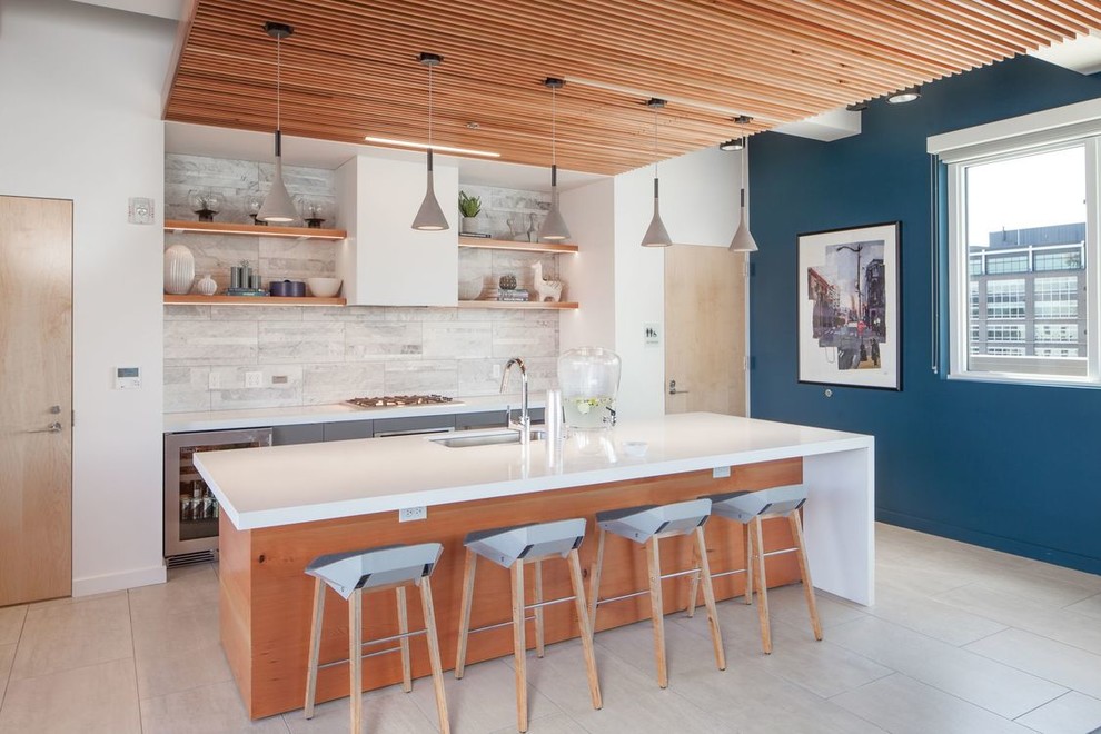 Foto di una cucina contemporanea con lavello sottopiano, paraspruzzi grigio, elettrodomestici in acciaio inossidabile, pavimento grigio e top bianco