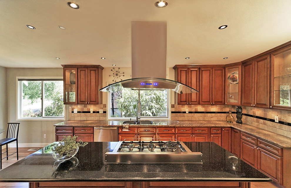Exemple d'une grande cuisine ouverte chic en U et bois brun avec un placard à porte vitrée, un plan de travail en granite, une crédence beige, une crédence en terre cuite et îlot.