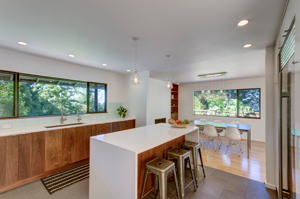 Cette image montre une cuisine minimaliste en bois brun avec un électroménager en acier inoxydable et îlot.