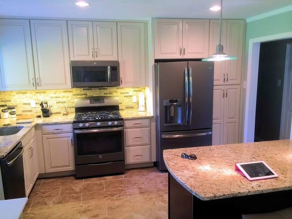 Example of a small classic galley porcelain tile eat-in kitchen design in St Louis with an undermount sink, raised-panel cabinets, white cabinets, granite countertops, beige backsplash, stone tile backsplash, colored appliances and an island