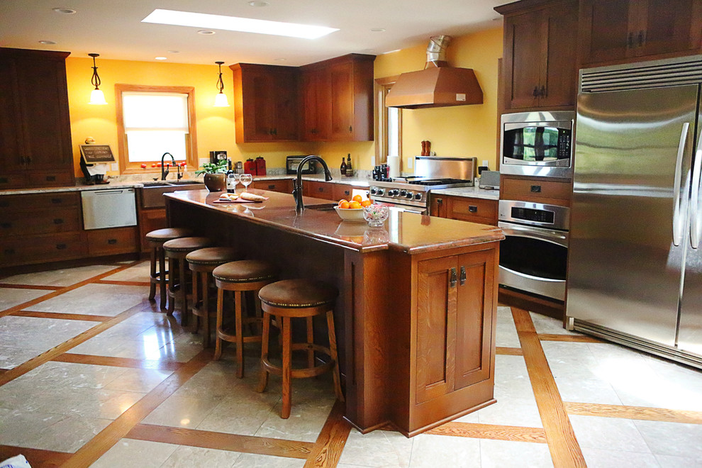 Esempio di un cucina con isola centrale con ante in legno bruno, paraspruzzi giallo, elettrodomestici in acciaio inossidabile e pavimento con piastrelle in ceramica