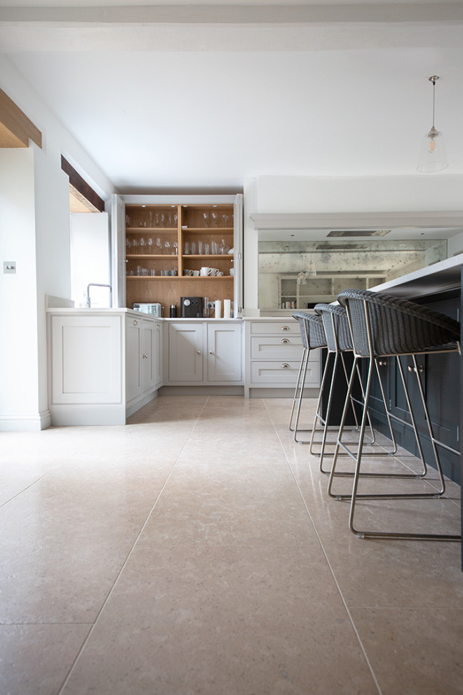 Large farmhouse kitchen in Other with limestone flooring and beige floors.