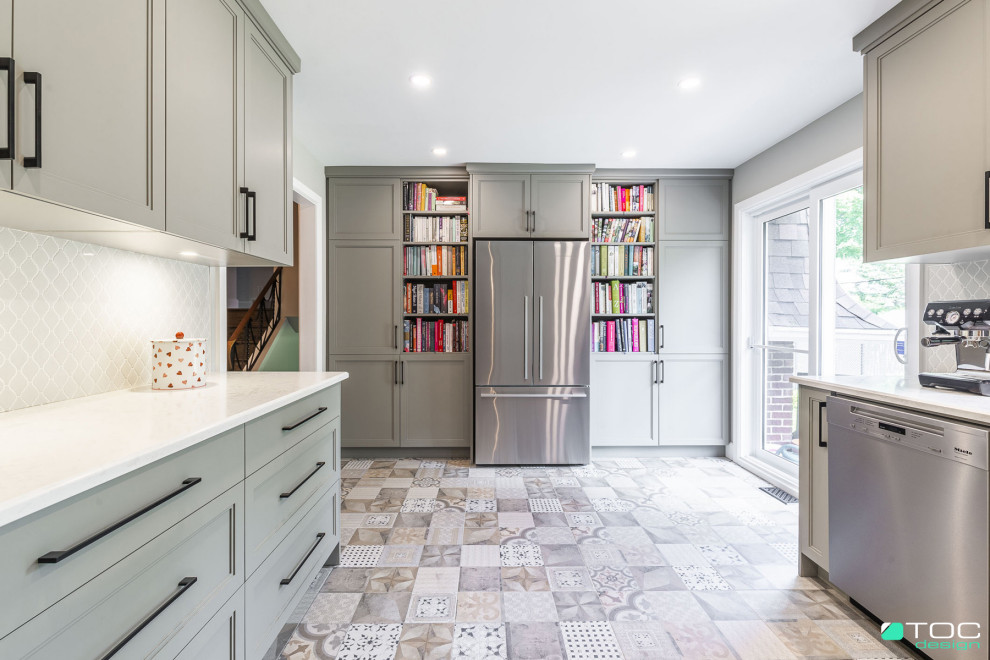 Photo of a medium sized rural u-shaped enclosed kitchen in Montreal with a submerged sink, recessed-panel cabinets, grey cabinets, engineered stone countertops, grey splashback, mosaic tiled splashback, stainless steel appliances, porcelain flooring, multi-coloured floors and white worktops.