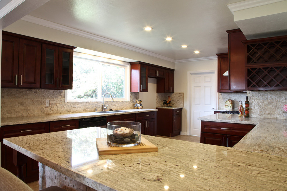 Example of a mid-sized trendy u-shaped porcelain tile and beige floor eat-in kitchen design in Los Angeles with a drop-in sink, raised-panel cabinets, dark wood cabinets, granite countertops, beige backsplash, mosaic tile backsplash, stainless steel appliances and an island