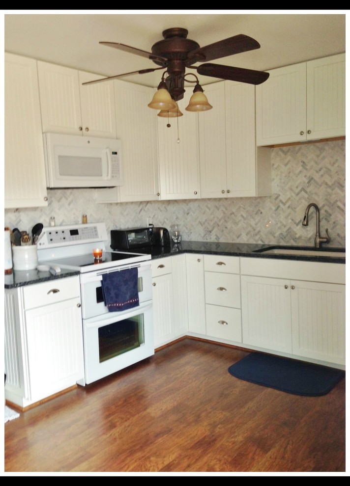 Landhausstil Küche in U-Form mit Schrankfronten im Shaker-Stil, weißen Schränken und Granit-Arbeitsplatte in Sonstige