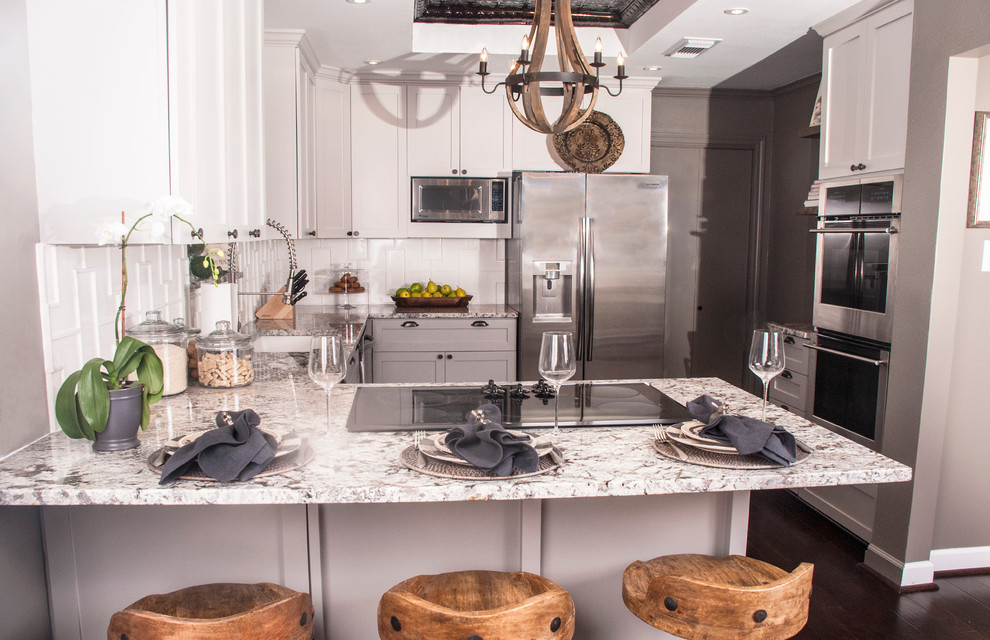 Esempio di una cucina chic con lavello sottopiano, ante in stile shaker, ante grigie, top in granito, paraspruzzi bianco, paraspruzzi in gres porcellanato e elettrodomestici in acciaio inossidabile