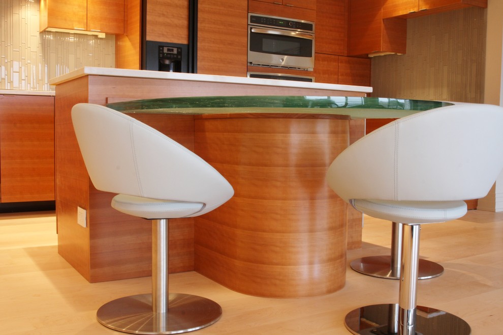 Exempel på ett modernt kök och matrum, med en undermonterad diskho, släta luckor, skåp i mellenmörkt trä, bänkskiva i kvarts, grått stänkskydd, stänkskydd i glaskakel, integrerade vitvaror och ljust trägolv