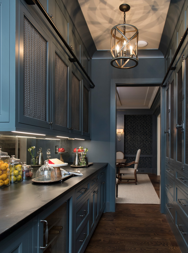 This is an example of a classic galley enclosed kitchen in Atlanta with recessed-panel cabinets, blue cabinets, soapstone worktops, mirror splashback, dark hardwood flooring, no island, brown floors and black worktops.