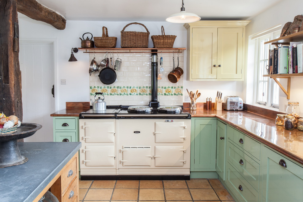 Landhaus Küche in L-Form mit Schrankfronten im Shaker-Stil, grünen Schränken, bunter Rückwand, Rückwand aus Metrofliesen, weißen Elektrogeräten und Kücheninsel in Hampshire
