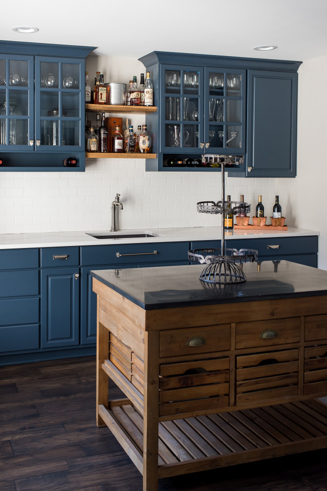 Zweizeilige, Mittelgroße Klassische Küche mit Unterbauwaschbecken, profilierten Schrankfronten, blauen Schränken, Quarzwerkstein-Arbeitsplatte, Küchenrückwand in Weiß, dunklem Holzboden, weißer Arbeitsplatte, Kücheninsel und braunem Boden in Indianapolis